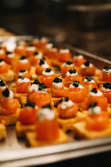 Cocktail catering Manila — tray of smoked salmon canapés topped with cream and caviar
